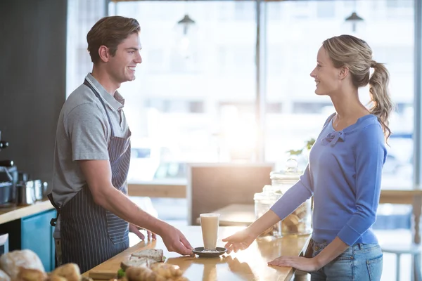 Waiter serving a cup of cold coffee to customer — Stock Photo, Image