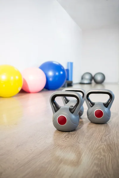 Três kettlebell cinza no chão de madeira — Fotografia de Stock