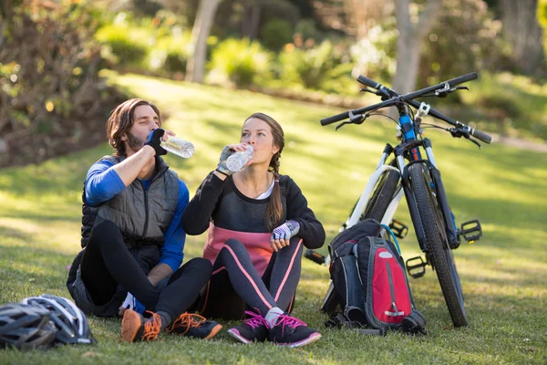 Biker paar ontspannen en met water — Stockfoto