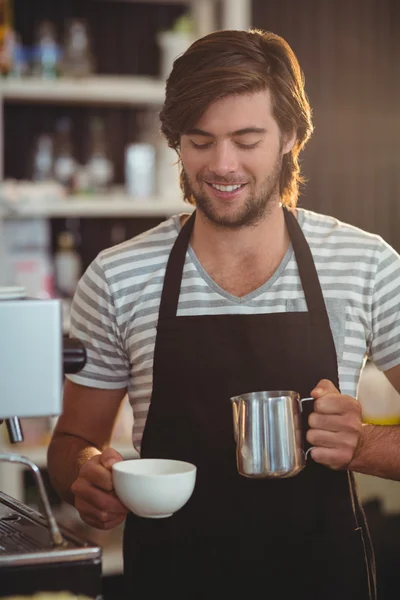 Garçom sorrindo fazendo xícara de café — Fotografia de Stock