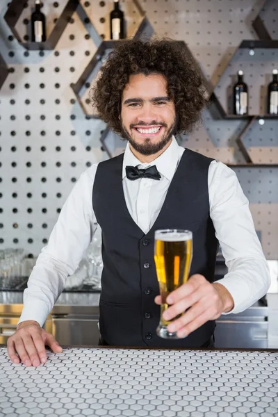 バーのカウンターでビールのガラスを保持しているバーテンダー — ストック写真