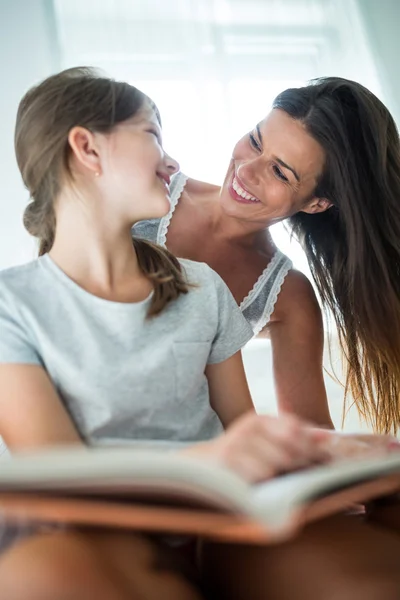 Мати і дочка взаємодіють під час читання книги — стокове фото