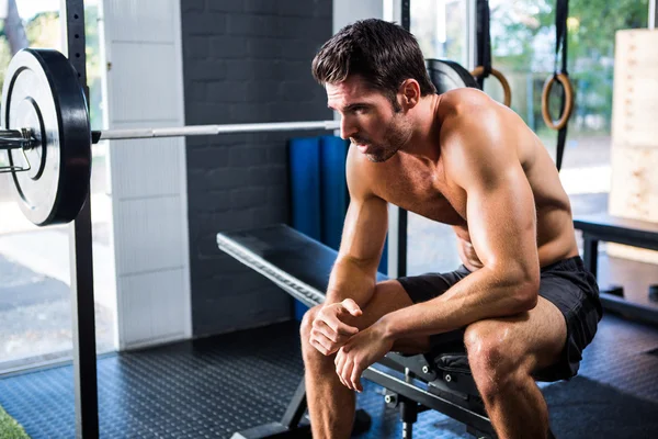 Man sitter på träningsutrustning i gymmet — Stockfoto