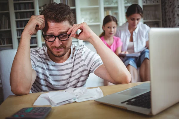 Besorgter Mann mit Scheinen und Laptop — Stockfoto