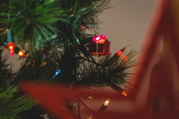 Luz de fada e pequena caixa de presente na árvore de Natal — Fotografia de Stock