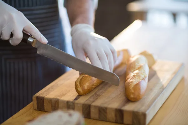 Waiter chopping bread roll on chopping board — Stock Photo, Image