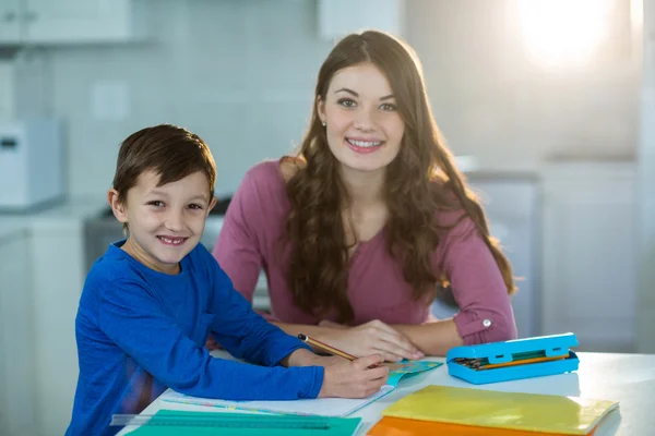 Moeder haar zoon helpen met huiswerk — Stockfoto