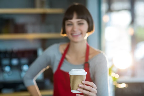 Kelnerka, trzymając jednorazowego kubka kawy — Zdjęcie stockowe