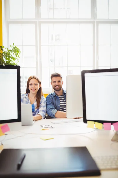 Cheerful graphic designers sitting at desk — Stock Photo, Image