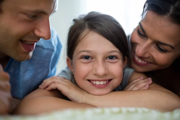 Parents and daughter lying in bedroom — Stock Photo, Image