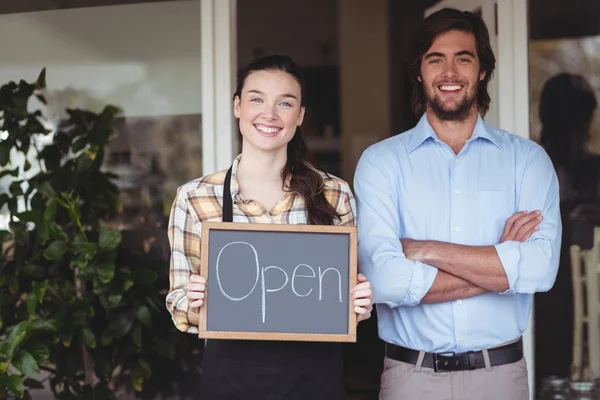 Man and waitress holding chalkboard with sign — Stock Photo, Image