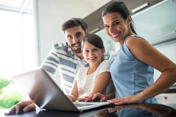 Porträt einer glücklichen Familie mit Laptop im Wohnzimmer — Stockfoto