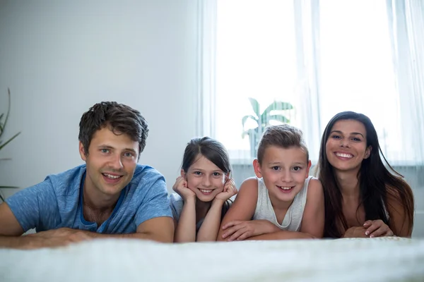 Parents and kids lying in bedroom — ストック写真