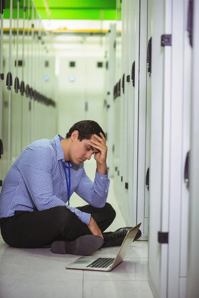 Técnico estressado no chão e olhando para laptop — Fotografia de Stock