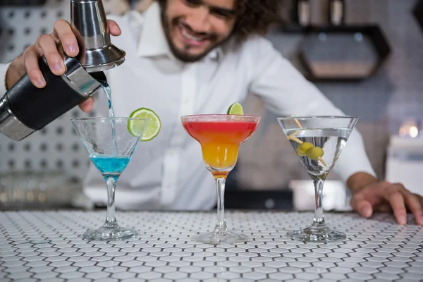 Barkeeper gießt Cocktail in Gläser — Stockfoto