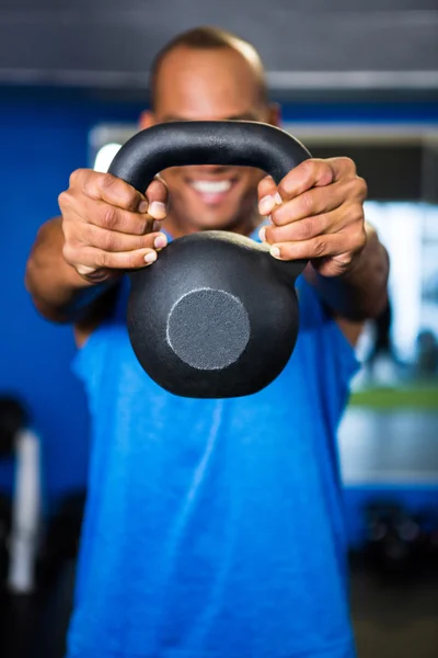 Man covering face with kettlebell in gym — Stock Photo, Image
