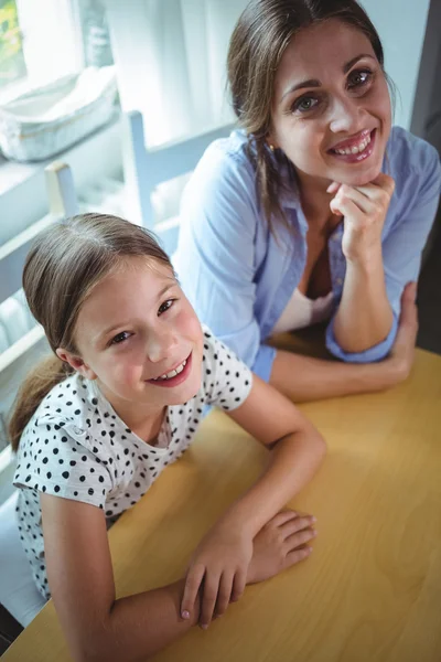 Anne ve kızı masanın üzerine eğilerek — Stok fotoğraf