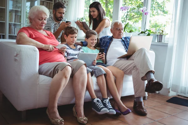 Flergenerations familj med bärbar dator, telefon och surfplatta — Stockfoto