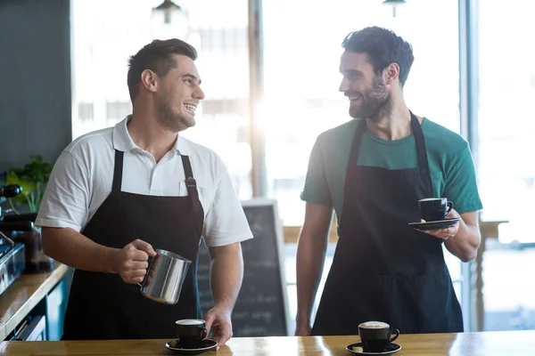 Servitören interagerar samtidigt kopp kaffe — Stockfoto