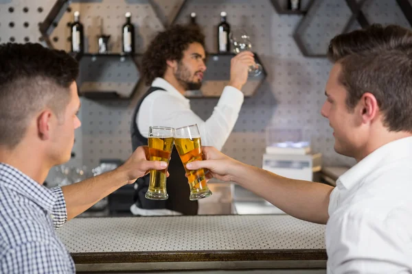 Dos hombres brindando por un vaso de cerveza — Foto de Stock