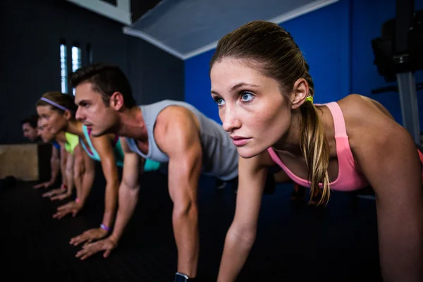 Athletes doing push-ups in gym — Stock Photo, Image