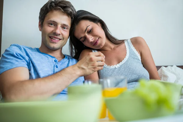 Lächelndes Paar beim Frühstück im Bett — Stockfoto