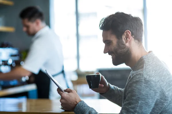 Man using phone while having coffee — Stock Photo, Image