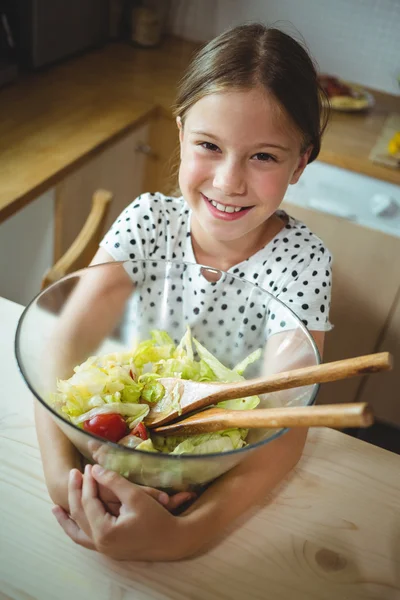 Dziewczynka gospodarstwa miseczka sałatki w kuchni — Zdjęcie stockowe