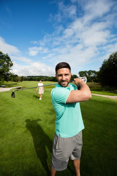Чоловік стоїть з гольф-клубом у полі для гольфу — стокове фото
