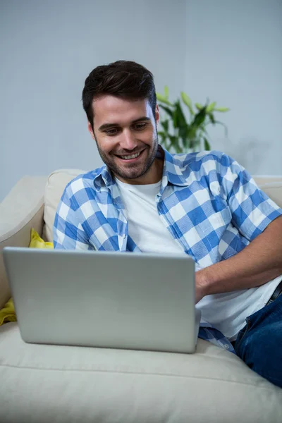 Man använder laptop medan du kopplar av på soffan — Stockfoto