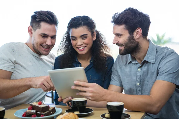 Three friends using a digital tablet — Stock Photo, Image