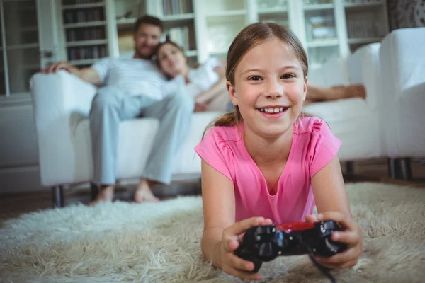 Menina deitado no tapete e jogar vídeo game — Fotografia de Stock