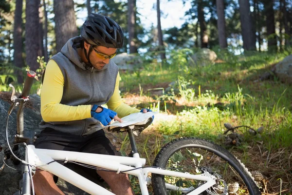 Mountain biker patrząc na mapę — Zdjęcie stockowe