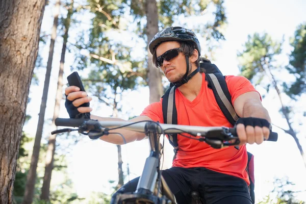 Гірський велосипедист використовує мобільний телефон — стокове фото