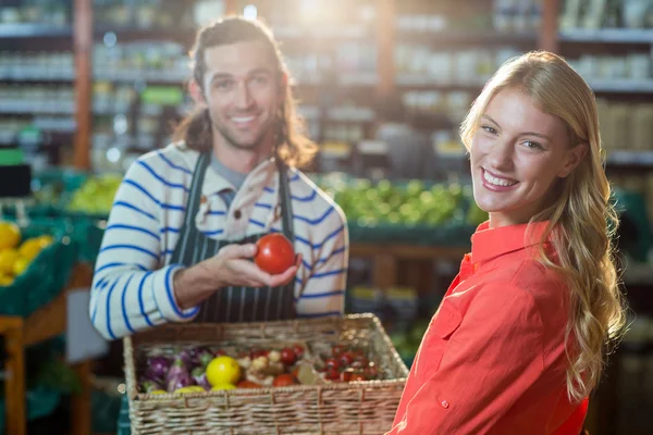 Personal masculino ayudando a la mujer en la selección de verduras frescas — Foto de Stock