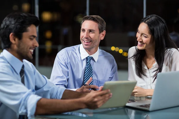 Empresário discutindo com colegas sobre tablet — Fotografia de Stock