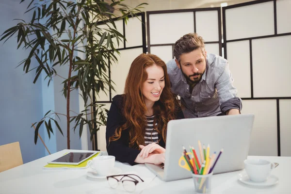 Selbstbewusste Kollegen mit Laptop im Kreativbüro — Stockfoto