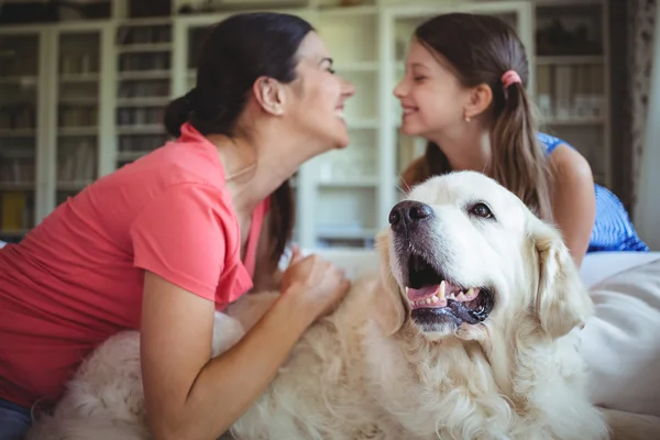 Moeder en dochter zitten met huisdier hond — Stockfoto