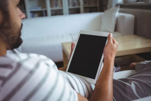 Muž pomocí tabletu v obývacím pokoji — Stock fotografie