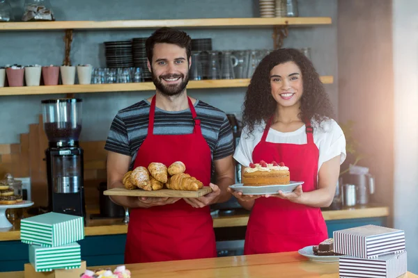 Číšník a servírka drží podnos croissanty — Stock fotografie
