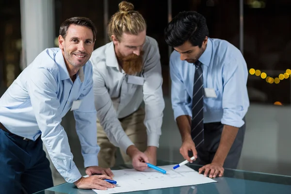 Empresário sorrindo enquanto os colegas discutem sobre o projeto — Fotografia de Stock