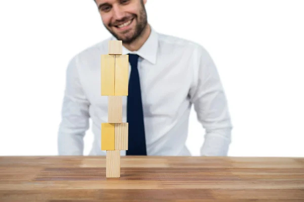 Zakenman houten blok te plaatsen op een toren — Stockfoto