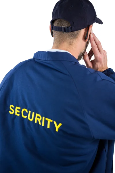 Security officer listening to earpiece — Stock Photo, Image