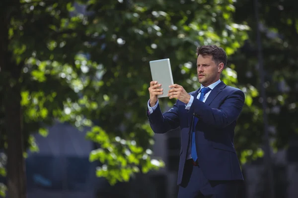 Hombre de negocios guapo usando tableta digital — Foto de Stock