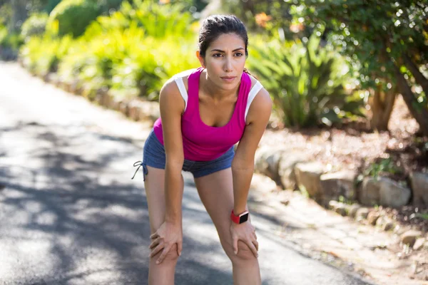 Mulher cansada fazendo uma pausa enquanto corre — Fotografia de Stock