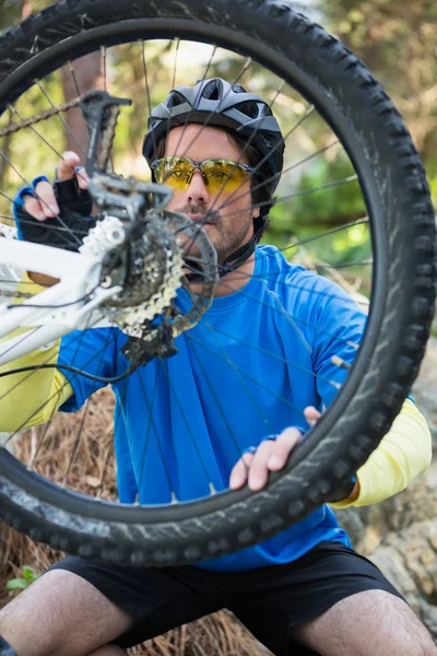 Чоловічий гірський велосипедист, що фіксує свій велосипедний ланцюг — стокове фото