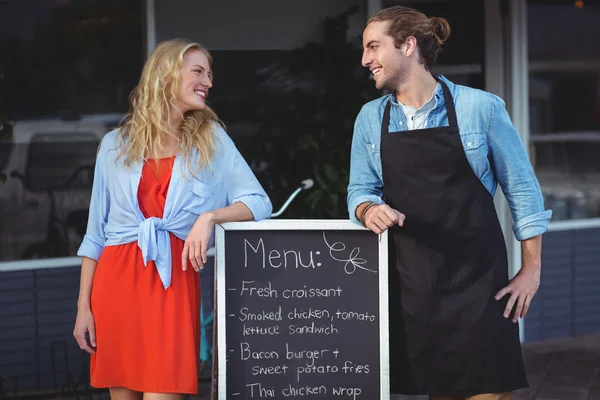 Číšník a žena stojící s menu desky — Stock fotografie