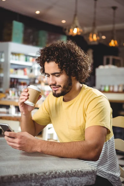 Ο άνθρωπος χρησιμοποιεί κινητό τηλέφωνο πίνοντας καφέ — Φωτογραφία Αρχείου