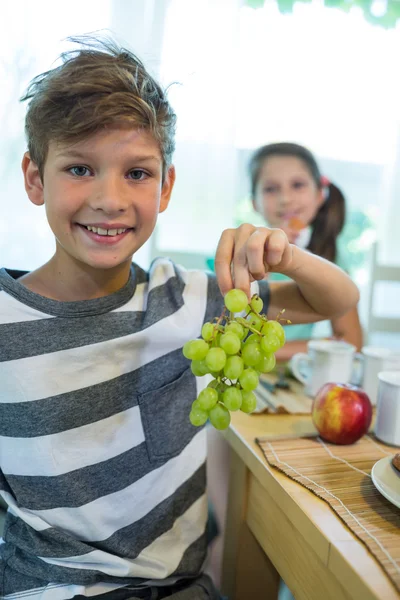 Jongen bedrijf tros druiven — Stockfoto