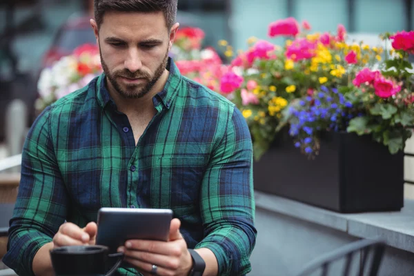 Empresario usando tableta mientras toma café — Foto de Stock